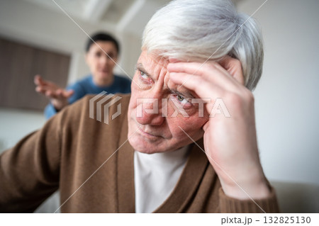 Close up portrait of weary elderly man enduring wife furious accusations and sharp reproach Close up portrait of weary elderly man enduring wife furious accusations and sharp reproach 132825130