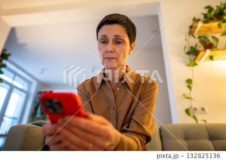 Focused older woman in phone procrastinating, ignoring reality. Digital addiction, screen overload Focused older woman in phone procrastinating, ignoring reality. Digital addiction, screen overload 132825136