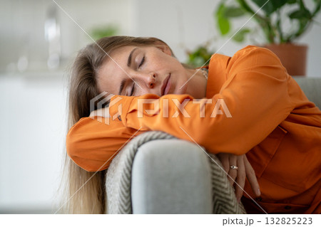 Middle-aged woman deeply tired and asleep on home sofa due to emotional exhaustion and fatigue Middle-aged woman deeply tired and asleep on home sofa due to emotional exhaustion and fatigue 132825223