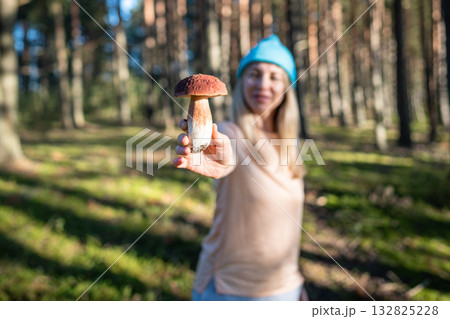 Pristine white Boletus specimen in hands of proud middle-aged woman found during walk in pine forest Pristine white Boletus specimen in hands of proud middle-aged woman found during walk in pine forest 132825228