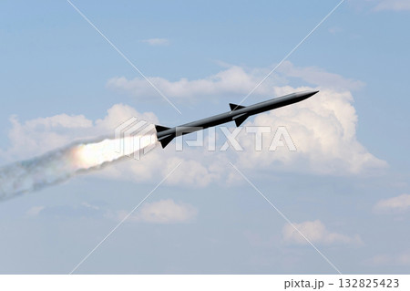 A combat rocket is flying above the clouds, smoke and fire from the rocket. A combat rocket is flying above the clouds, smoke and fire from the rocket. 132825423
