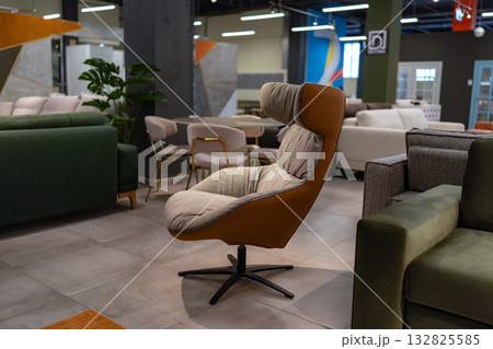 Armchair, furniture, showroom display. Modern stylish upholstered chair in a spacious retail store. 132825585