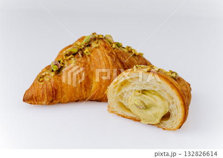 Fresh pistachio croissant with creamy filling on white background, gourmet bakery dessert 132826614