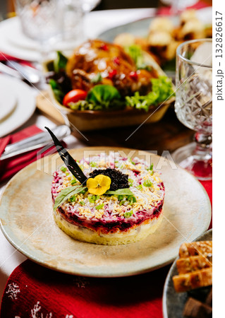 Traditional layered beetroot salad Herring under a fur coat with caviar and herbs on festive table 132826617