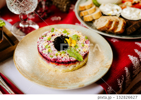 Traditional layered beetroot salad Herring under a fur coat with caviar and herbs on festive table 132826627