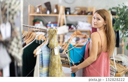 woman chooses clothes from the summer collection woman chooses clothes from the summer collection 132828222