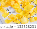 ピアノの楽譜の上に広がる黄色の薔薇の花びら 132828231