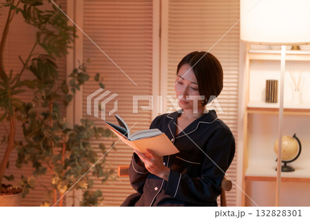 夜、部屋で読書する女性 132828301