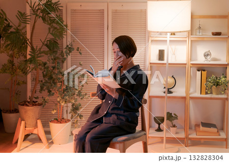 夜、部屋で読書する女性 132828304