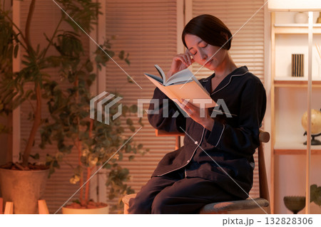 夜、部屋で読書する女性 132828306