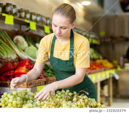 woman seller stands near the counter and puts a wine woman seller stands near the counter and puts a wine 132828374