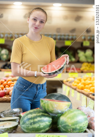 Young woman shopper choosing sliced watermelon in store Young woman shopper choosing sliced watermelon in store 132828381