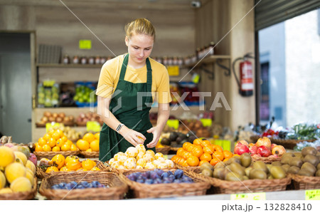 Teenage girl seller puts yellow plums in store Teenage girl seller puts yellow plums in store 132828410