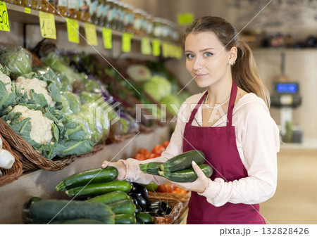 Woman seller puts zucchini on the counter 132828426