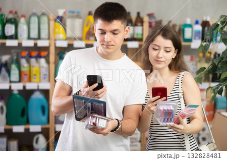 Couple scans the barcode of shaver packaging Couple scans the barcode of shaver packaging 132828481