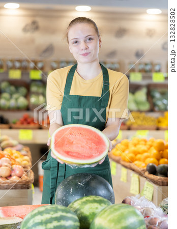 Grocery store saleswoman offers to buy ripe watermelon Grocery store saleswoman offers to buy ripe watermelon 132828502