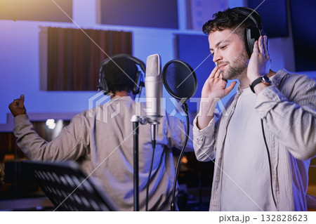 Musician, headphones or singing microphone in neon studio for album recording, night performance or radio media industry. Men, singer or artist friends in production collaboration, theater or karaoke Musician, headphones or singing microphone in neon studio for album recording, night performance or radio media industry. Men, singer or artist friends in production collaboration, theater or karaoke 132828623