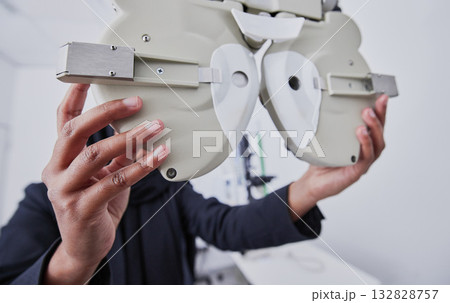 Optometry, machine and optometrist preparing for a eye test in the optic or healthcare clinic. Vision, ophthalmology and hands of a female optician with optical equipment for a exam in a store. 132828757
