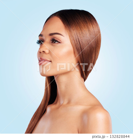 Face, skincare and hair care of woman in studio isolated on a blue background. Hairstyle cosmetics, thinking and aesthetics of young female model with salon treatment for growth, texture and balayage 132828844