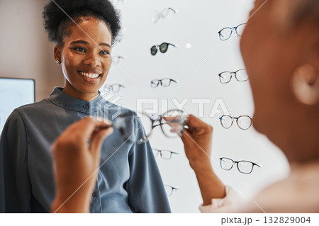 Glasses, black woman and retail customer with store worker and optician looking at lens. Eye consulting, smile and eyewear assessment in a frame shop for vision test and prescription exam for eyes Glasses, black woman and retail customer with store worker and optician looking at lens. Eye consulting, smile and eyewear assessment in a frame shop for vision test and prescription exam for eyes 132829004
