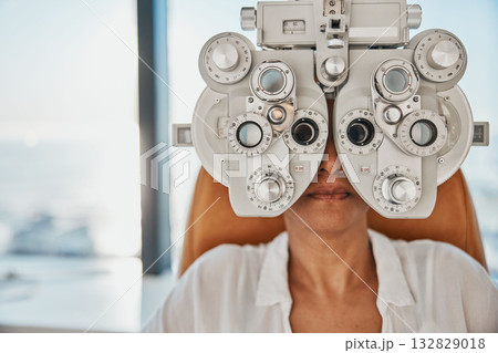 Vision, eye exam and woman in optometry test for wellness, eyesight and optical assessment. Healthcare, optometrist consultation and patient with medical equipment, phoropter and lens for eyes 132829018