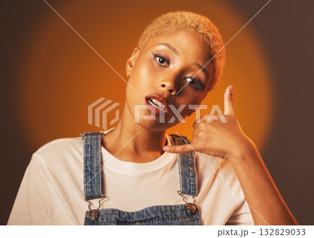 Black woman, portrait and call me hand sign, emoji or gesture for marketing against a studio background. African American female face looking and showing hang loose or contact advertising on mockup 132829033