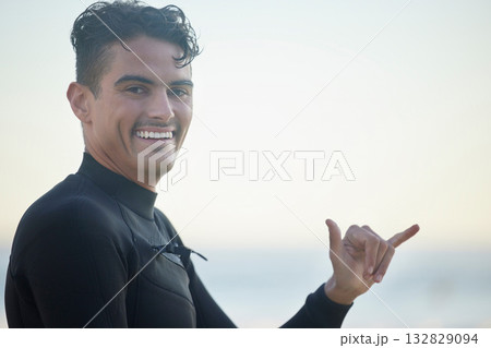 Shaka, portrait and man surfer at the beach for water sports training or exercise while on vacation. Happy, smile and male athlete with a hang loose hand sign ready for a surfing workout in Australia Shaka, portrait and man surfer at the beach for water sports training or exercise while on vacation. Happy, smile and male athlete with a hang loose hand sign ready for a surfing workout in Australia 132829094