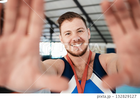 Gymnastics, sports and man athlete taking a selfie after winning a medal in a competition. Happy, smile and portrait of proud male gymnast winner taking a picture after training or practice in arena. Gymnastics, sports and man athlete taking a selfie after winning a medal in a competition. Happy, smile and portrait of proud male gymnast winner taking a picture after training or practice in arena. 132829127