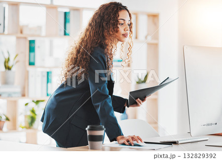 Businesswoman, computer and document in schedule planning, preparation or strategy standing at office desk. Female employee manager checking desktop PC in analysis or project plan at the workplace 132829392