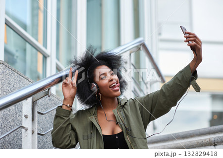 Selfie, campus and black woman student taking picture to update social media in a city with a peace sign or hand gesture. Photo, internet and young female making funny face with tongue online in town Selfie, campus and black woman student taking picture to update social media in a city with a peace sign or hand gesture. Photo, internet and young female making funny face with tongue online in town 132829418