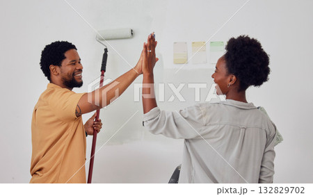 Painting, success or black couple high five in DIY, home renovation or house remodel together with a paintbrush. Happy smile, woman and fun African man with teamwork or support for decoration designs 132829702
