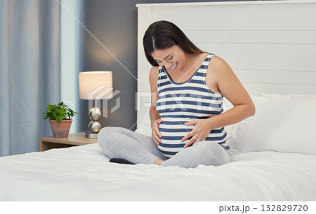 Pregnant stomach, woman and home bedroom while happy about bonding and growth. Mother to be person with hands on abdomen for healthy pregnancy development, body wellness and care or love on her bed Pregnant stomach, woman and home bedroom while happy about bonding and growth. Mother to be person with hands on abdomen for healthy pregnancy development, body wellness and care or love on her bed 132829720