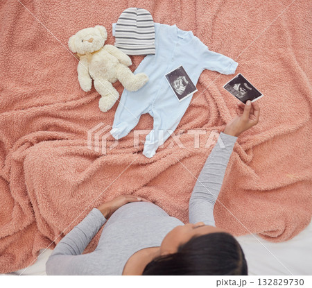 Pregnant, baby clothes and mother with scan, x ray and teddy bear in bed of kid, infant and child. Pregnancy love, family home and top view of excited and happy woman with prenatal picture in bedroom 132829730