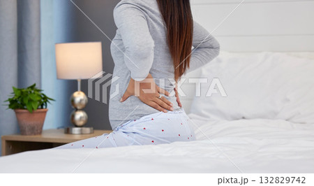 Tired, feeling and pregnant woman with back pain on a bed for rest, injury and fatigue. Healthcare, stress and girl with backache during pregnancy in her bedroom with morning sickness and cramps Tired, feeling and pregnant woman with back pain on a bed for rest, injury and fatigue. Healthcare, stress and girl with backache during pregnancy in her bedroom with morning sickness and cramps 132829742