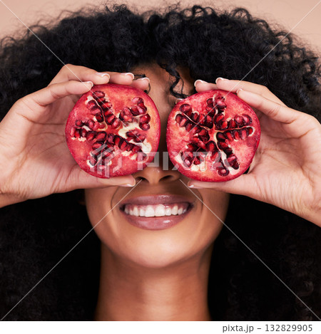 Hair care, face and black woman with pomegranate in studio isolated on a brown background. Fruit, skincare and happy female model holding food for healthy diet, nutrition or vitamin c and minerals. Hair care, face and black woman with pomegranate in studio isolated on a brown background. Fruit, skincare and happy female model holding food for healthy diet, nutrition or vitamin c and minerals. 132829905