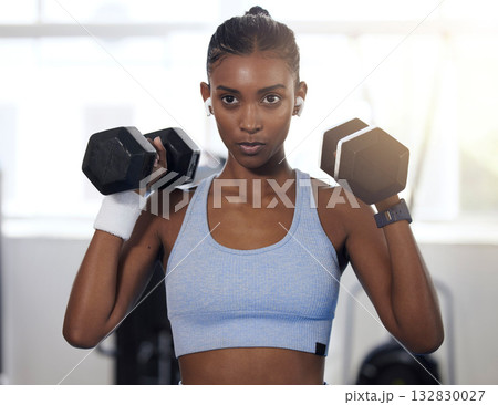 Woman, fitness and weightlifting dumbbells at gym for intense exercise, workout or strength training. Serious female lifting weights and exercising for healthy wellness or bodybuilding at health club 132830027