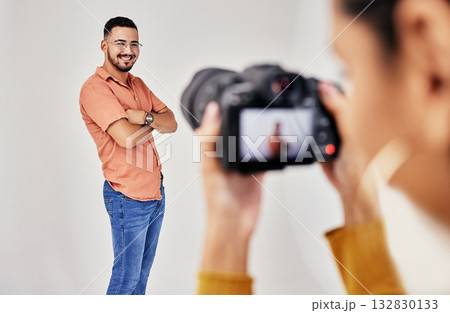 Shooting, photography and photographer with man model in studio for creative, advertising and image. Media, backstage and professional woman videographer with guy, camera and equipment for photoshoot 132830133