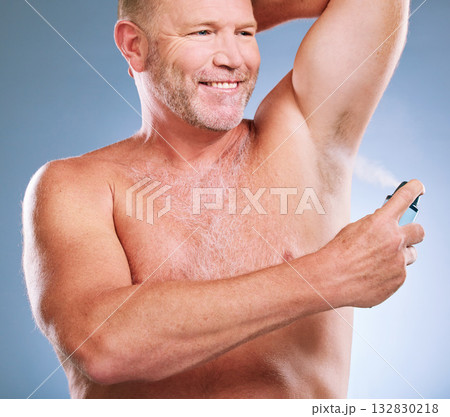 Man, armpit and spray in skincare hygiene, grooming or smelling fresh against a studio background. Elderly male smiling and spraying deodorant under arms in satisfaction for aroma or clean cosmetics 132830218
