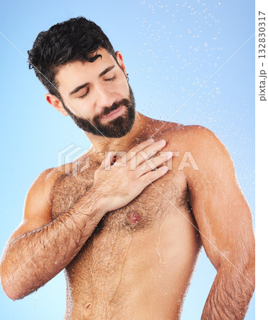 Water drops, shower and man for hygiene self care and cleaning on a blue background in studio. Body of a aesthetic model person for skincare, health and wellness with splash for dermatology cosmetics Water drops, shower and man for hygiene self care and cleaning on a blue background in studio. Body of a aesthetic model person for skincare, health and wellness with splash for dermatology cosmetics 132830317