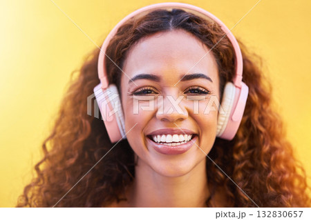 Music, portrait and smile with a black woman listening to the radio outdoor on a yellow wall background. Headphones, energy and face with an attractive young female streaming audio sound for fun Music, portrait and smile with a black woman listening to the radio outdoor on a yellow wall background. Headphones, energy and face with an attractive young female streaming audio sound for fun 132830657