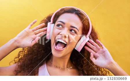 Music, thinking and wow with a black woman listening to the radio outdoor on a yellow wall background. Headphones, energy and face with an attractive young female streaming audio sound for fun 132830669