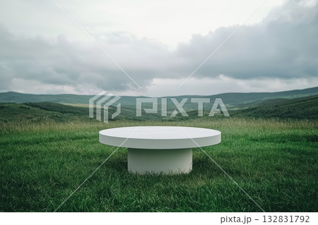 Large White Pedestal Table in a Minimalist Green Landscape Under Dramatic Cloudy Sky Large White Pedestal Table in a Minimalist Green Landscape Under Dramatic Cloudy Sky 132831792