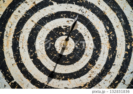 Dartboard with a Single Dart Perfectly Hitting the Bullseye in a Compelling Close-Up View Dartboard with a Single Dart Perfectly Hitting the Bullseye in a Compelling Close-Up View 132831836