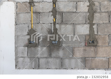 Worker is marking lebel for electrical outlets and wall switches location on new kitchen wall. 132832958