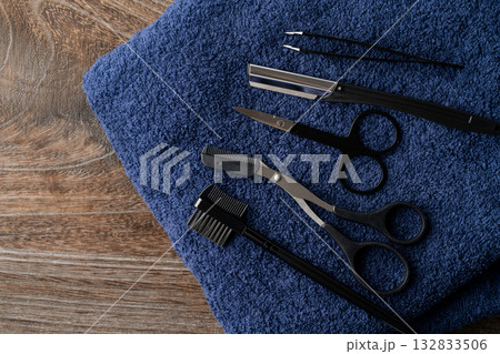 紺色のタオルの上に置かれた眉毛の手入れの道具セット 132833506