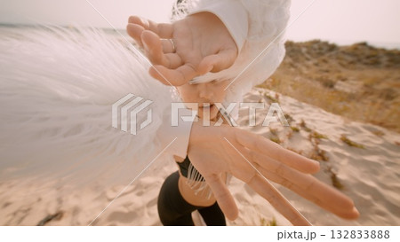 A Stunning and Dramatic Fashion Moment at the Beach Featuring Flowing White Feathers 132833888