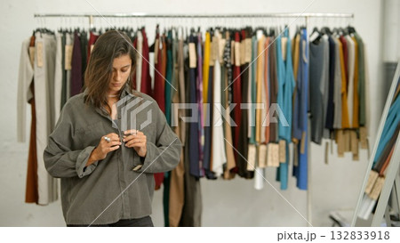 A Fashion Designer in a Studio with a vibrant Clothing Rack full of various items 132833918