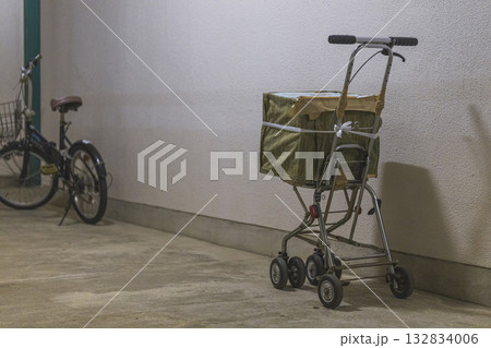 団地の片隅に置かれた歩行補助具と自転車 132834006