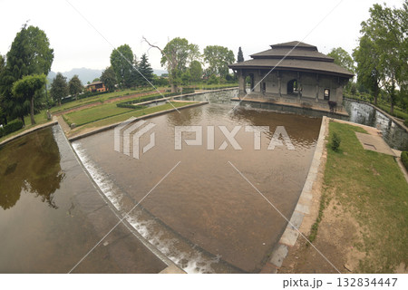 The buildings and ponds that decorate the Shalimar Bagh Gardens are a beautiful Mughal garden in Srinagar, Jammu and Kashmir, India. The gardens are decorated with fountains, ponds and plants. 132834447