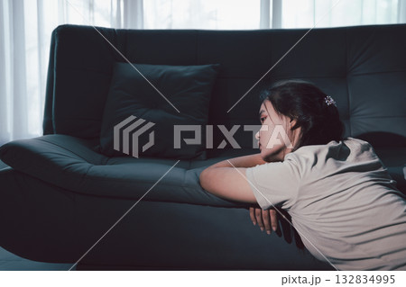 Sorrowful woman sat alone, overwhelmed by emotion, her sad and unhappy expression revealing deep despair, stress and distress left feeling depressed. sorrowful sad, despair alone, depressed stress 132834995